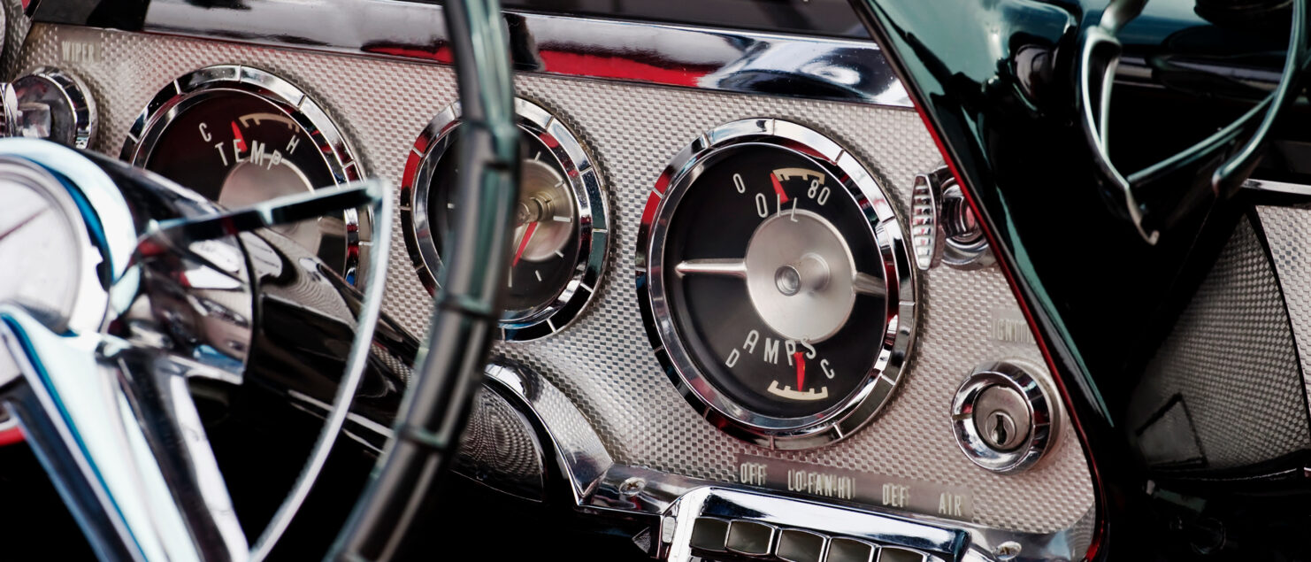 The interior of a classic car, showing the dashboard and steering wheel